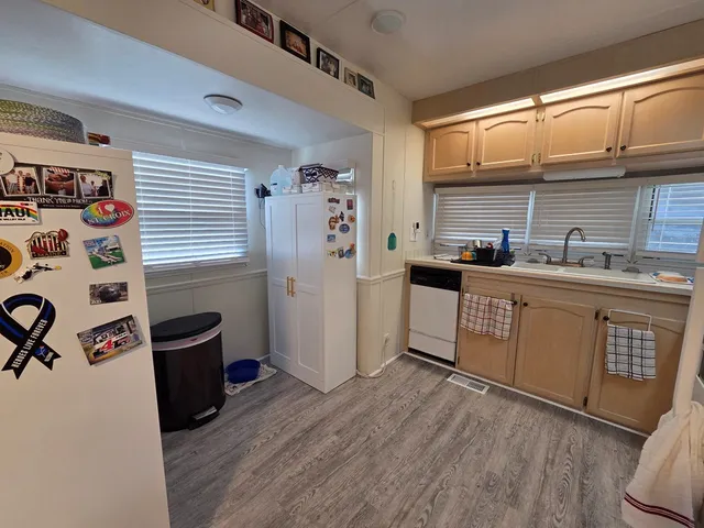a kitchen with a sink a refrigerator and cabinets