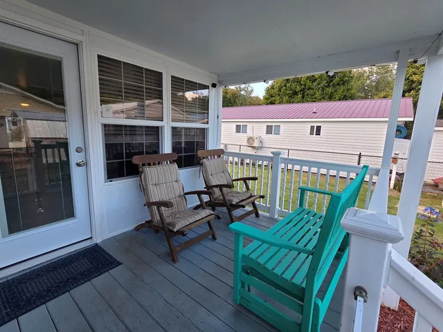 a view of a patio with table and chairs with wooden floor and fence