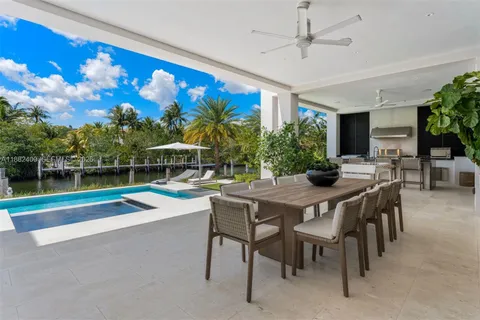 a kitchen with stainless steel appliances a table and chairs in it