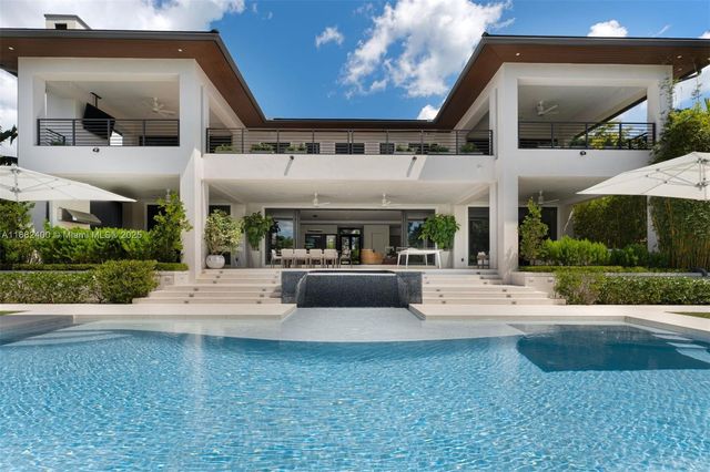 a front view of a house with a yard and potted plants