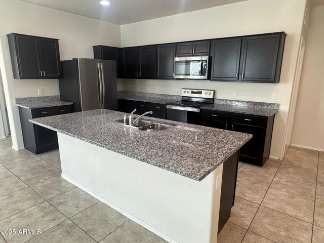 a kitchen with a sink a counter space cabinets and a window