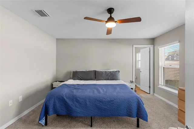 a bed sitting in a room next to a window and a chandelier