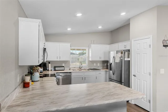a large kitchen with stainless steel appliances lots of counter space and wooden floor