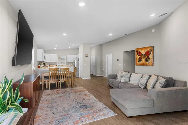 a living room with furniture wooden floor and a flat screen tv