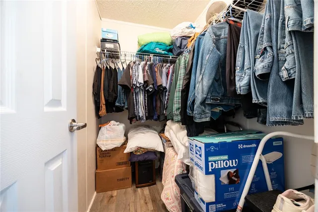 a view of walk in closet with clothes and shoes