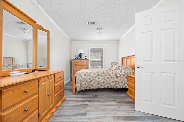 a spacious bedroom with a bed and a dresser