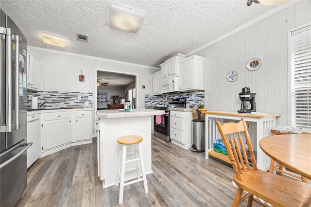 a kitchen with wooden floors and appliances
