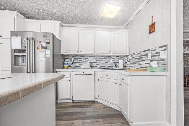 a kitchen with stainless steel appliances white cabinets and a refrigerator