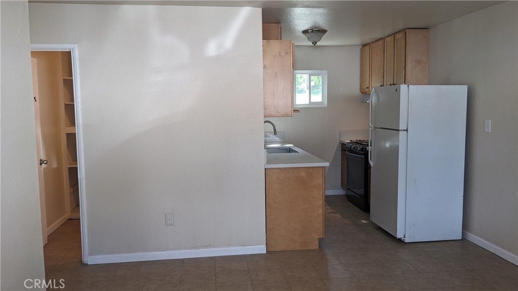 25401 Spring Street, Unit 4 Perris, CA 92570 - Photo 1 of 2 a room with refrigerator and mirror