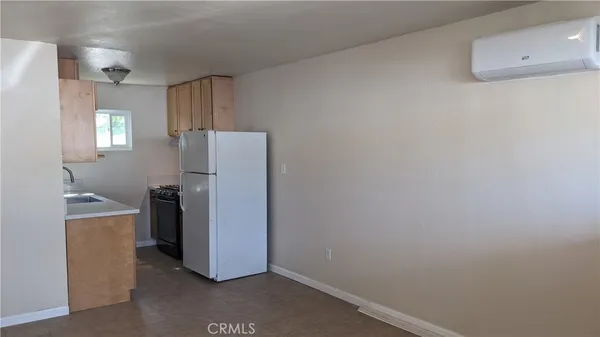 a view of a kitchen with refrigerator and window