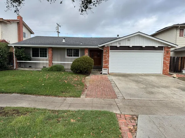 a front view of a house with a garden and yard