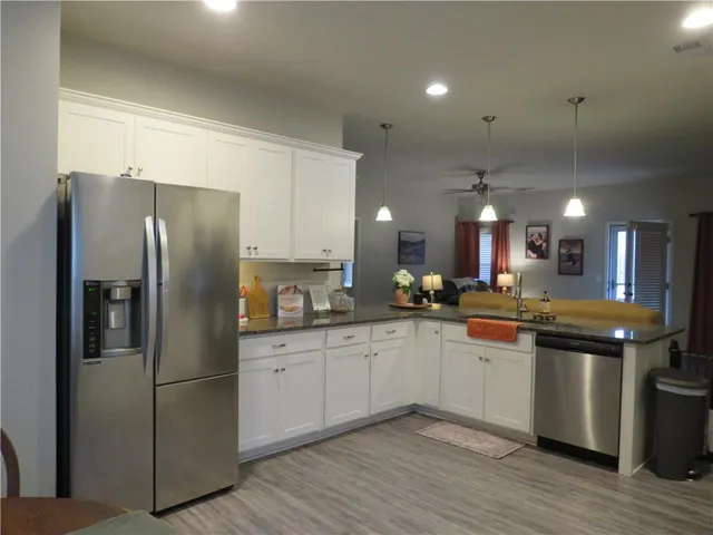 a kitchen with stainless steel appliances granite countertop a refrigerator and a sink
