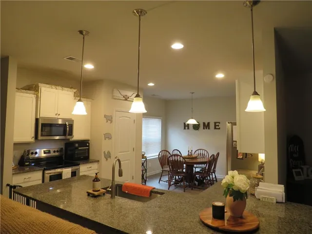 a kitchen with refrigerator and chairs