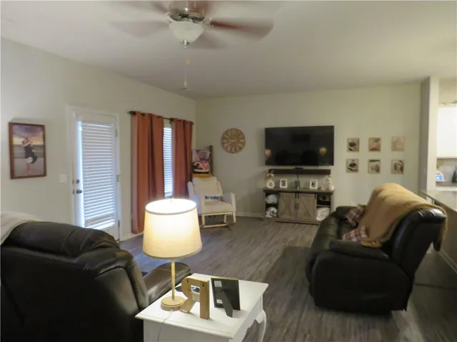 a living room with furniture a flat screen tv and kitchen view