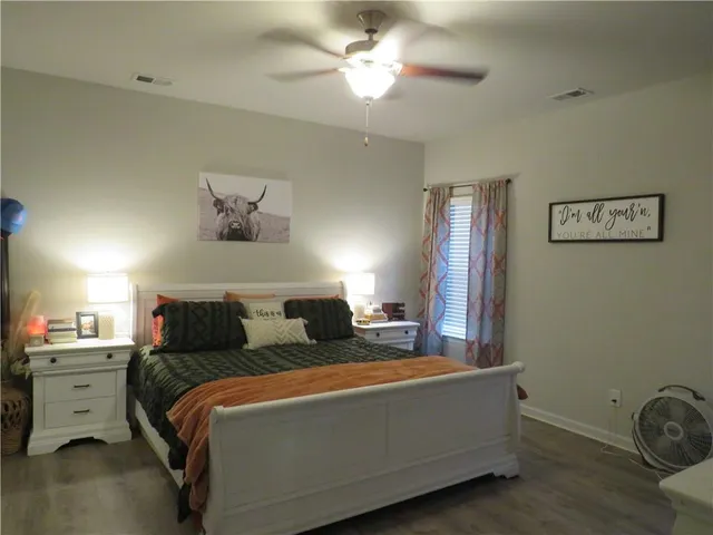a bedroom with a large bed and a chandelier