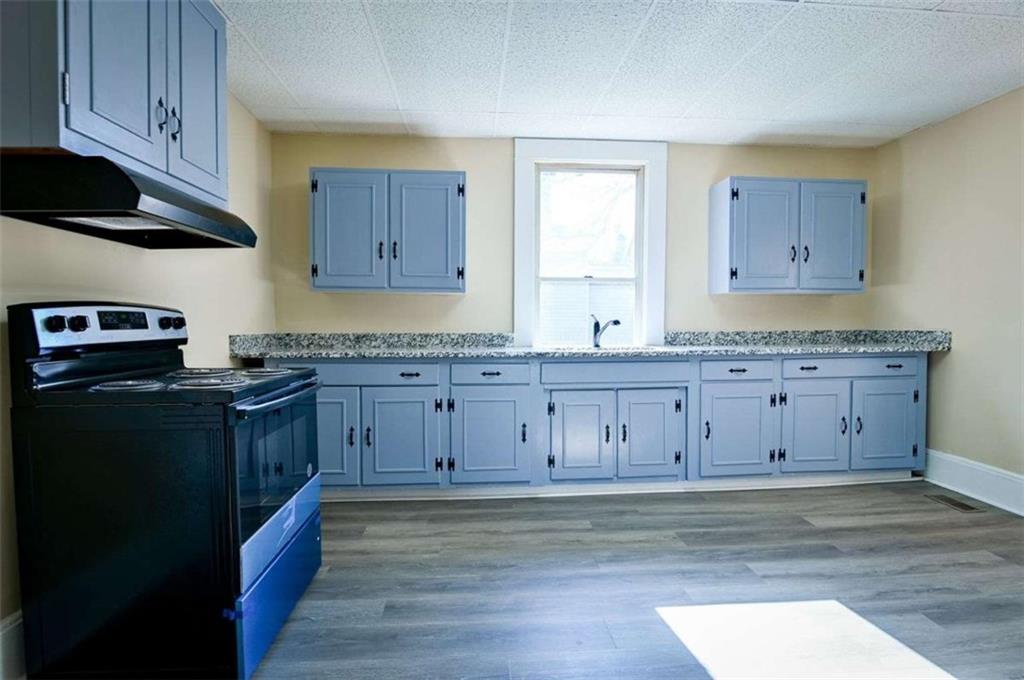 a kitchen with granite countertop wooden cabinets and stainless steel appliances
