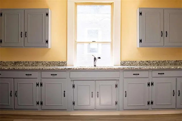a kitchen with granite countertop wooden cabinets and a stove