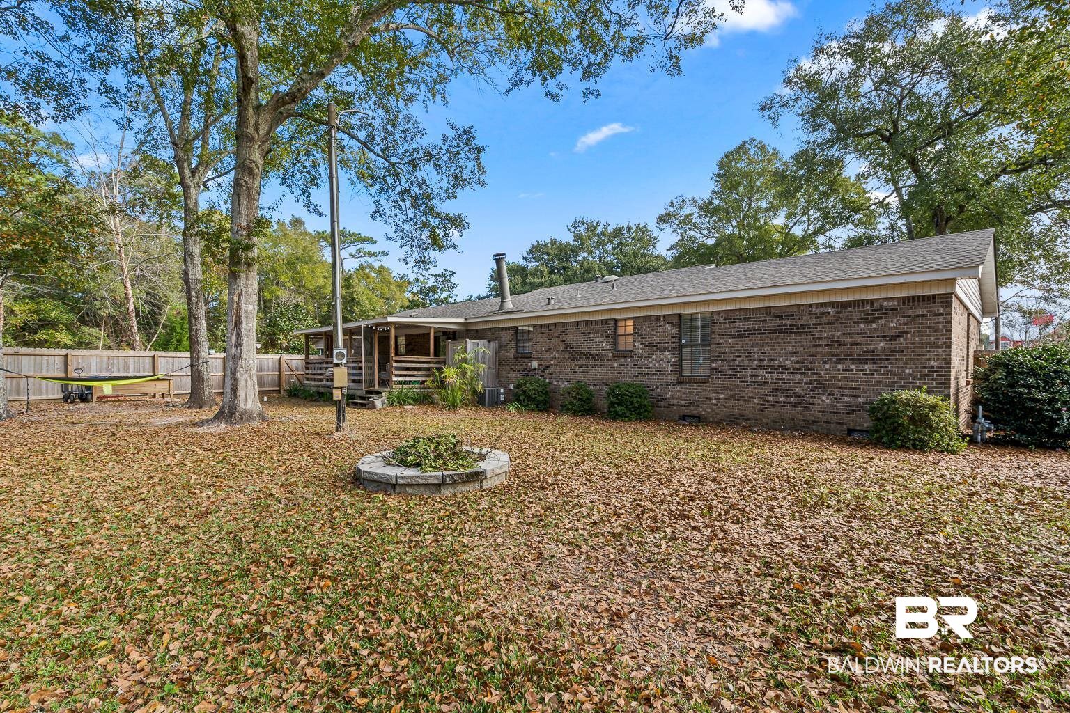 6801 Piney Woods Road Foley, AL 36535 - Photo 67 of 74 Back of house with brick siding, a fenced backyard, and a deck