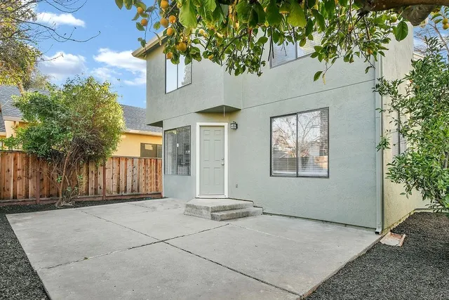 a view of an house with backyard and trees
