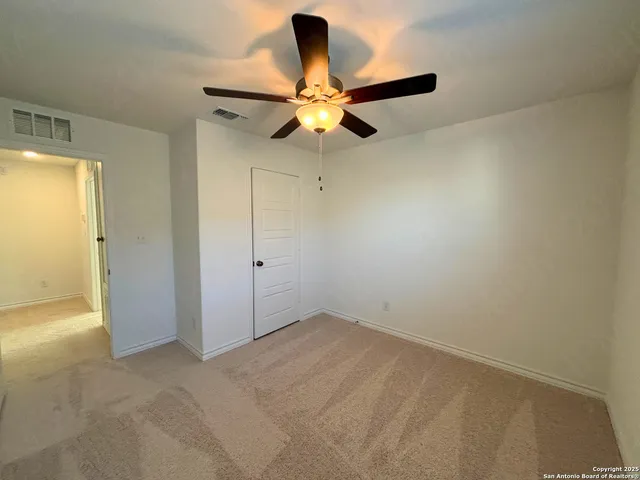 an empty room with closet and chandelier fan