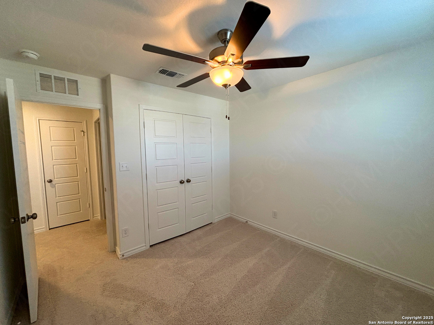 1032 Oriole Way Marion, TX 78124 - Photo 15 of 18 an empty room with closet and a chandelier fan