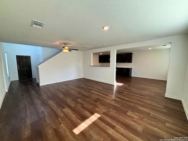 a view of empty room with wooden floor
