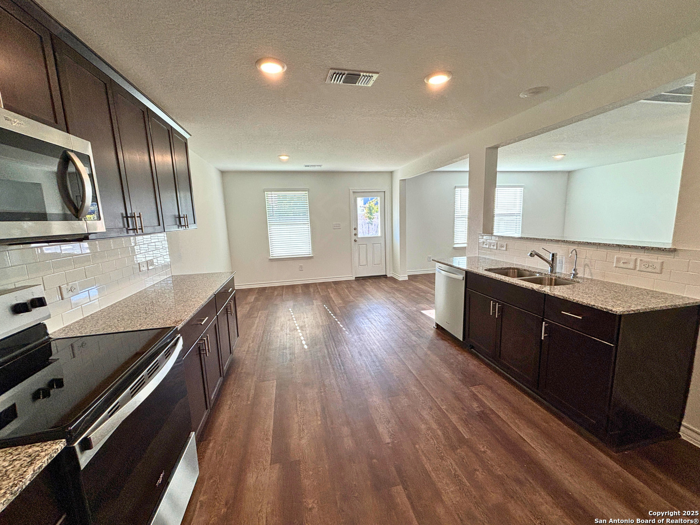 1032 Oriole Way Marion, TX 78124 - Photo 7 of 18 a large kitchen with stainless steel appliances wooden floor a stove and a microwave