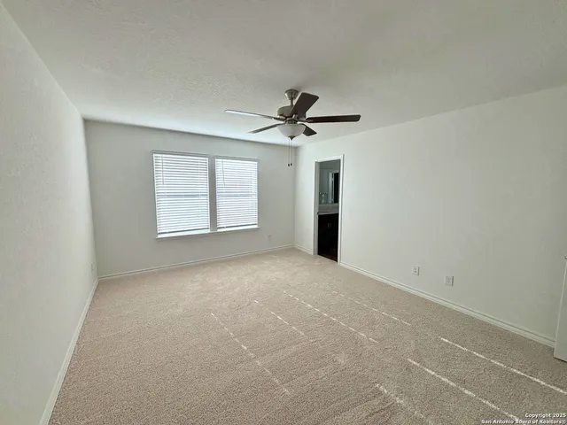 a view of a livingroom with a ceiling fan and window