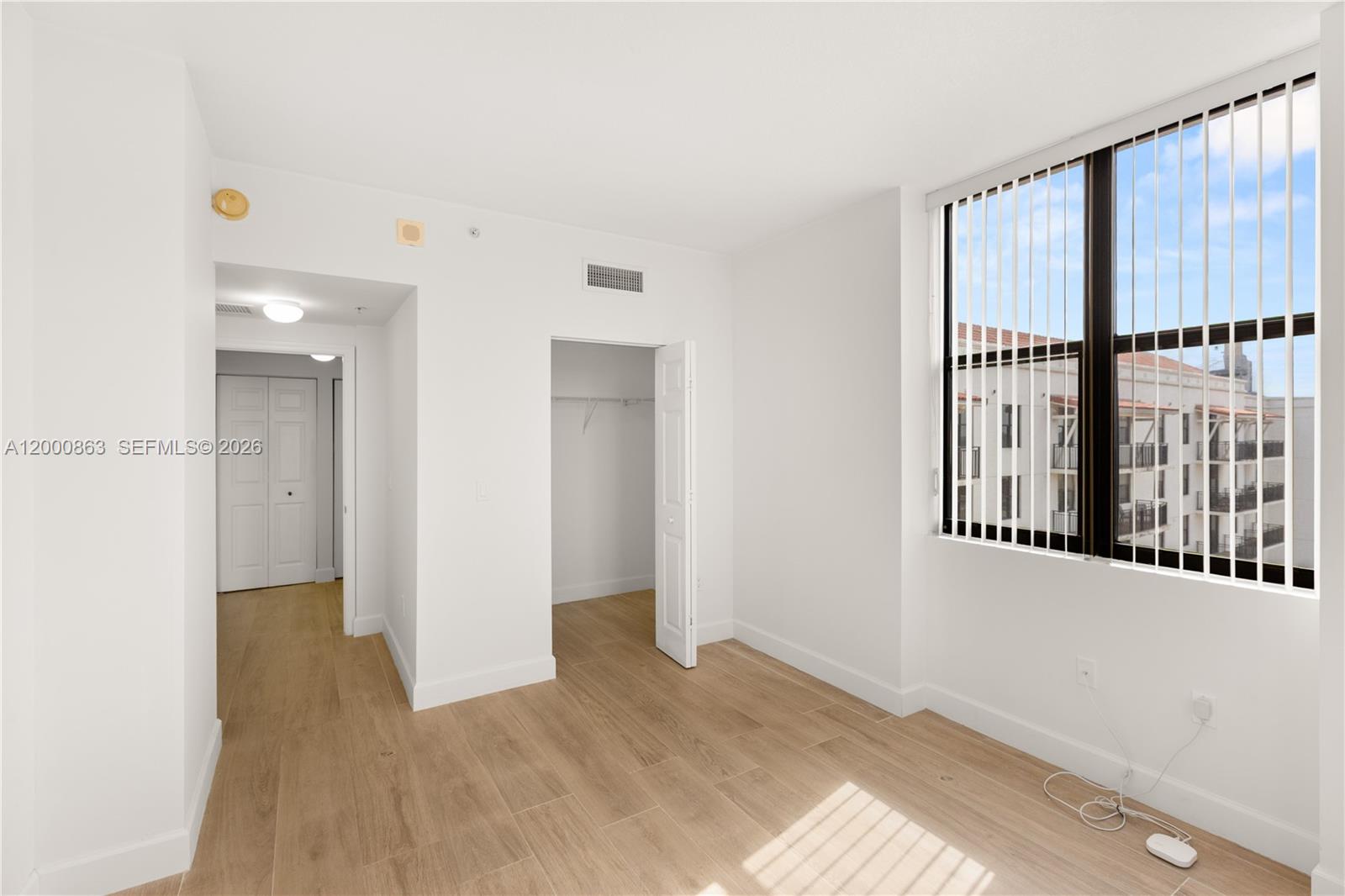 888 Douglas Road, Unit PH01 Coral Gables, FL 33134 - Photo 15 of 31 a view of an empty room with wooden floor and a window