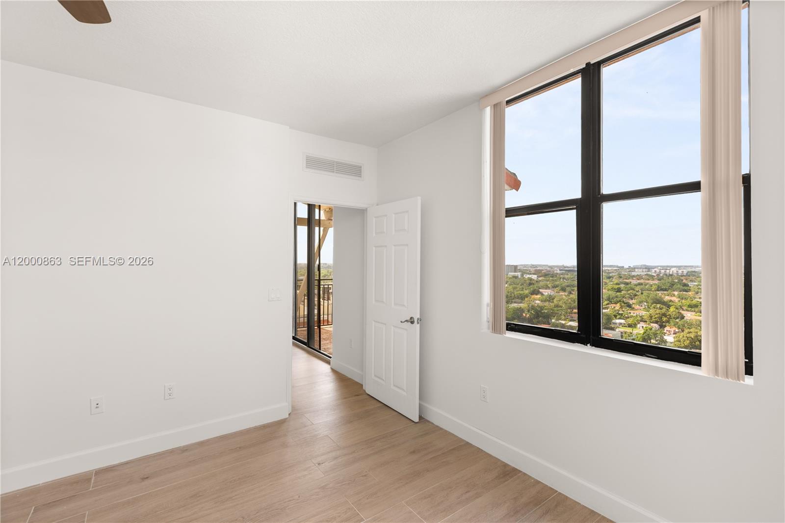 888 Douglas Road, Unit PH01 Coral Gables, FL 33134 - Photo 23 of 31 an empty room with wooden floor and windows