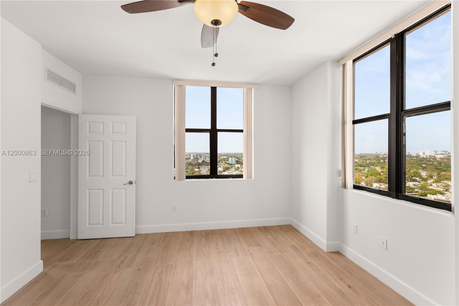 888 Douglas Road, Unit PH01 Coral Gables, FL 33134 - Photo 24 of 31 a view of an empty room with a window and wooden floor
