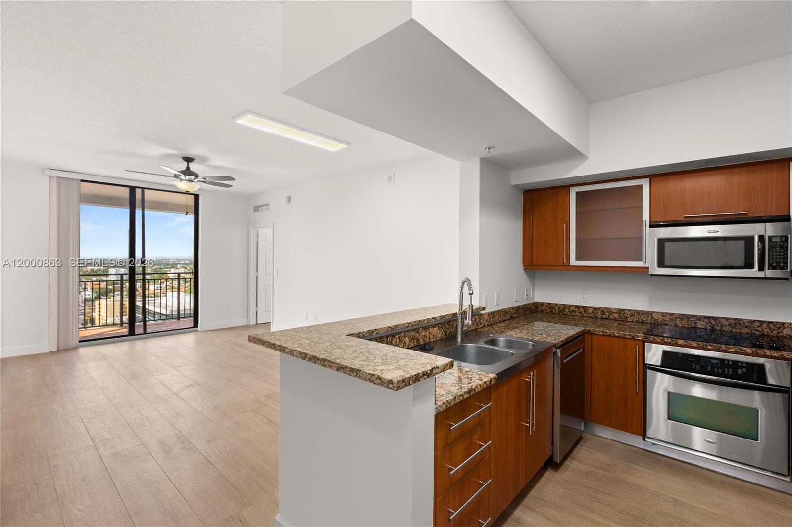 888 Douglas Road, Unit PH01 Coral Gables, FL 33134 - Photo 5 of 31 a kitchen with stainless steel appliances granite countertop a stove and a sink