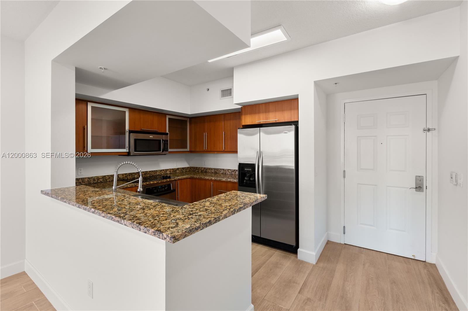 888 Douglas Road, Unit PH01 Coral Gables, FL 33134 - Photo 6 of 31 a kitchen with stainless steel appliances granite countertop a refrigerator a oven a sink with granite countertops and wooden floor