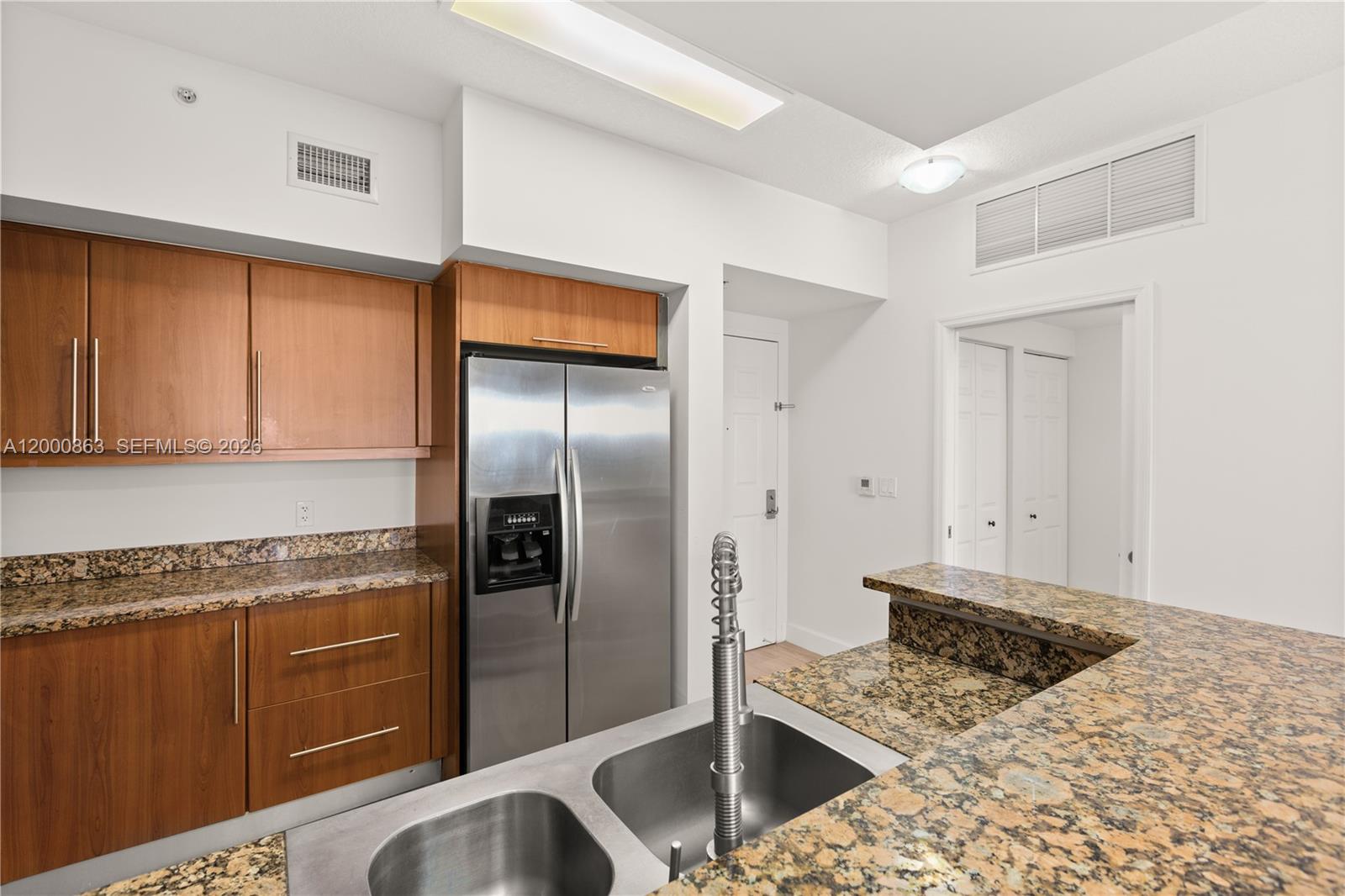 888 Douglas Road, Unit PH01 Coral Gables, FL 33134 - Photo 7 of 31 a kitchen with stainless steel appliances kitchen island granite countertop a refrigerator and a sink