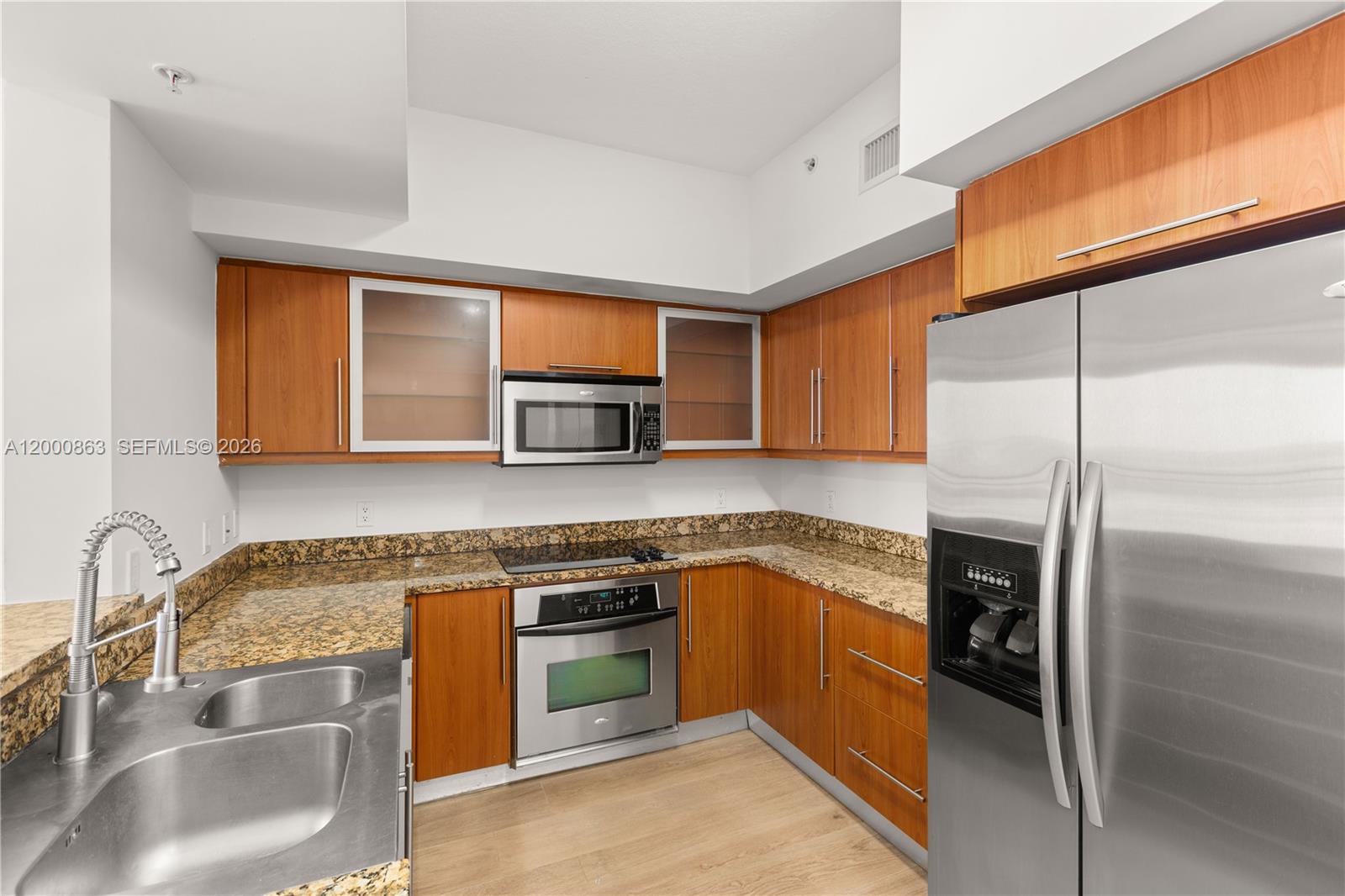 888 Douglas Road, Unit PH01 Coral Gables, FL 33134 - Photo 8 of 31 a kitchen with stainless steel appliances granite countertop a sink a stove and a refrigerator