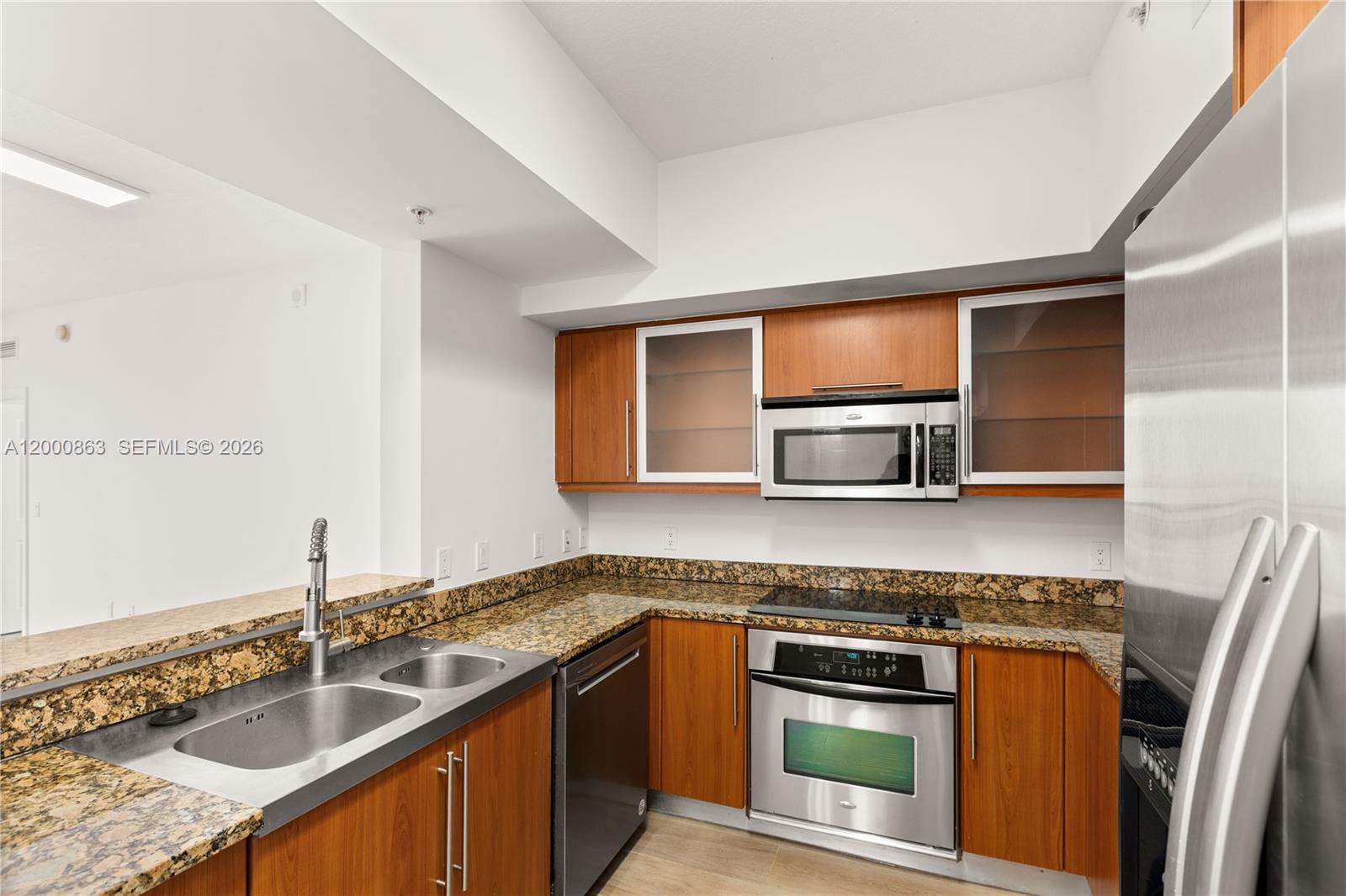 888 Douglas Road, Unit PH01 Coral Gables, FL 33134 - Photo 9 of 31 a kitchen with stainless steel appliances granite countertop a sink stove and microwave