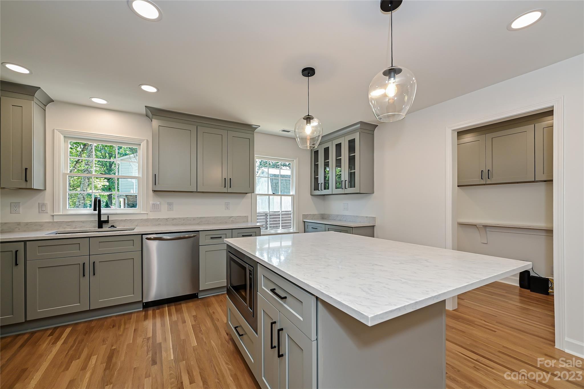 5024 Providence Road Charlotte, NC 28226 - Photo 17 of 39 a kitchen with a stove center island a sink cabinets and wooden floor