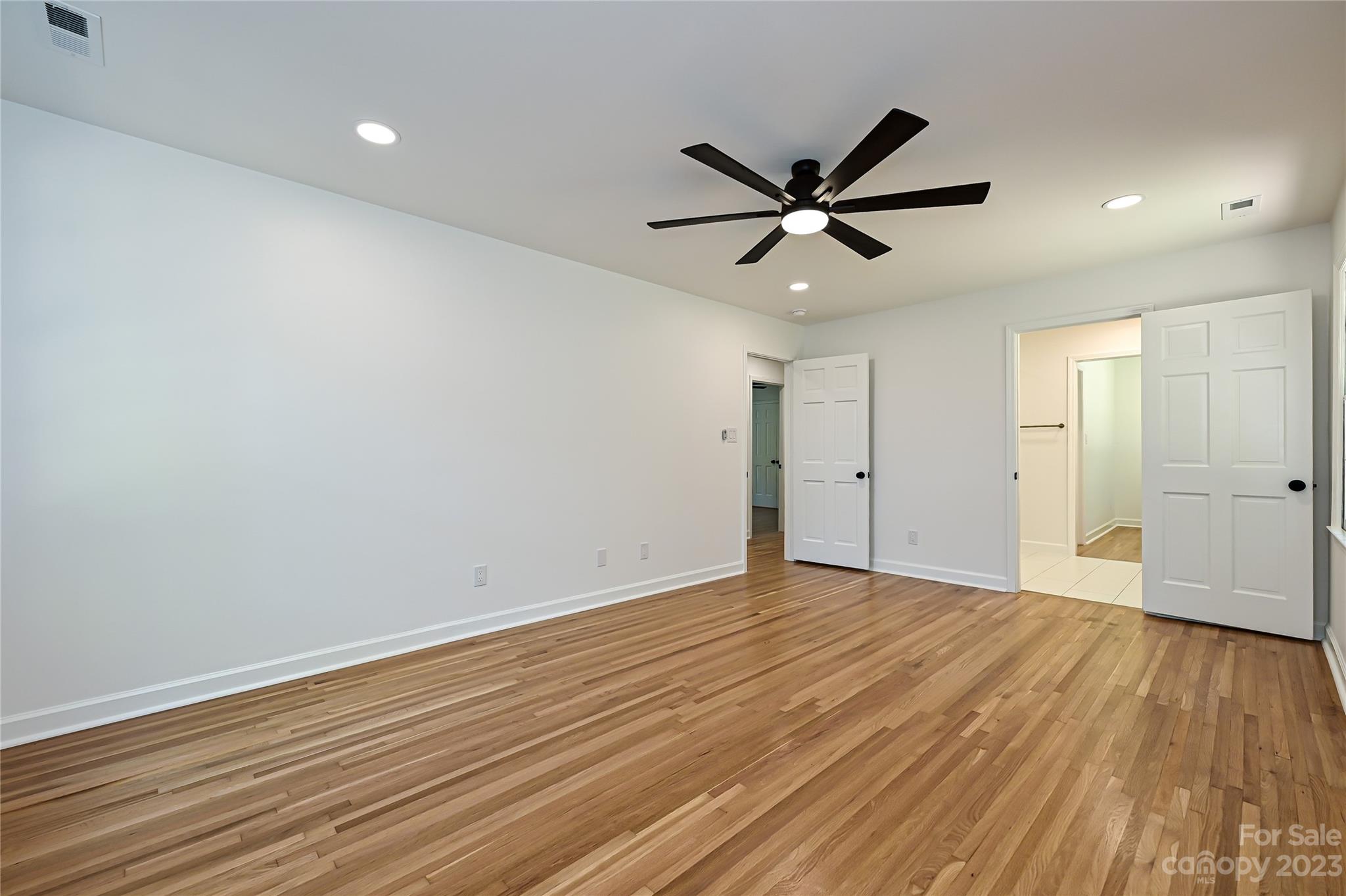 5024 Providence Road Charlotte, NC 28226 - Photo 22 of 39 an empty room with wooden floor a ceiling fan and a ceiling fan