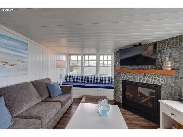 a living room with furniture a flat screen tv and a fireplace