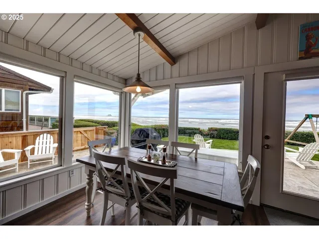 a view of a dining room with furniture large windows and wooden floor