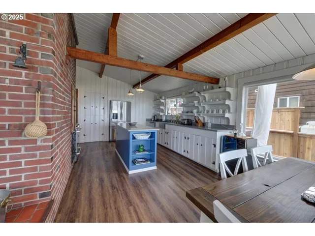 a living room with furniture wooden floor and a kitchen view