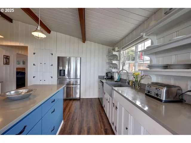 a kitchen with stainless steel appliances granite countertop a sink a stove and a wooden floors