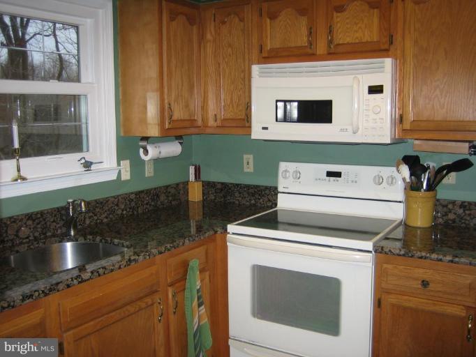 285 West Bay Front Road Lothian, MD 20711 - Photo 12 of 26 a kitchen with granite countertop a sink stove and microwave