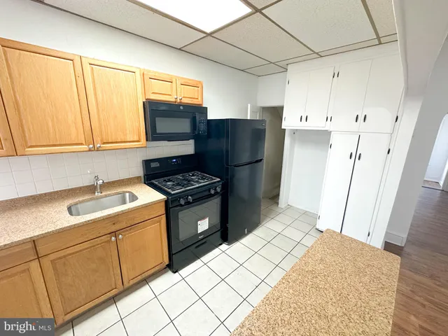 a kitchen with a refrigerator sink and cabinets