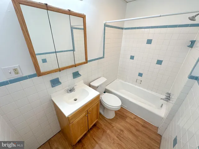 a bathroom with a sink a toilet a mirror and shower