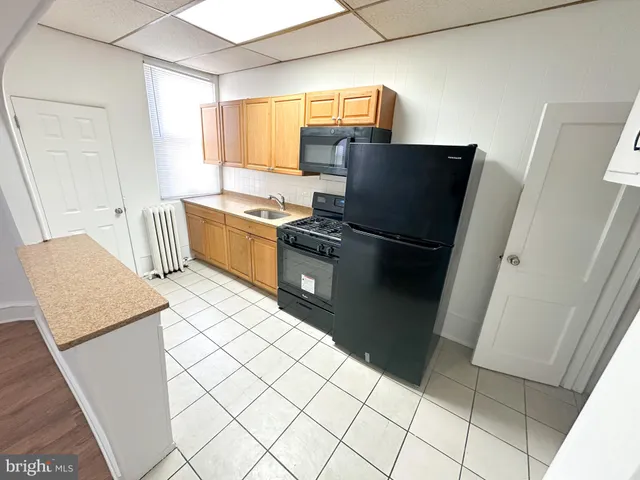 a kitchen with granite countertop a refrigerator and a stove top oven