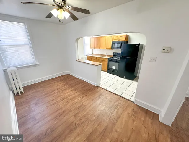 a view of a kitchen with wooden floor electronic appliances and windows