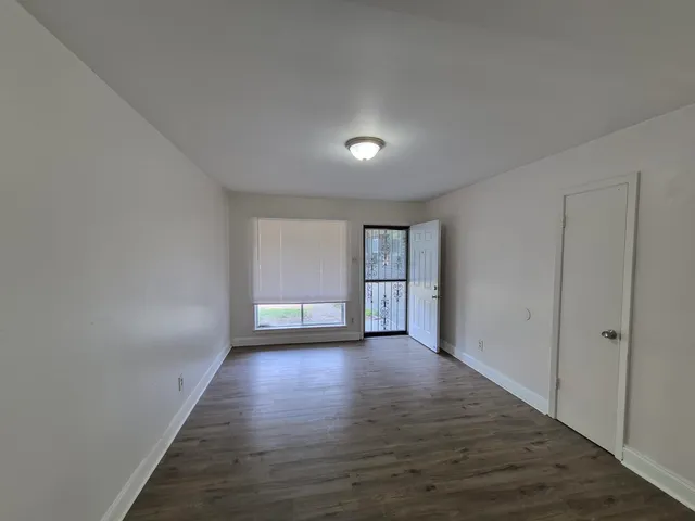 a kitchen with a refrigerator stove and wooden floor