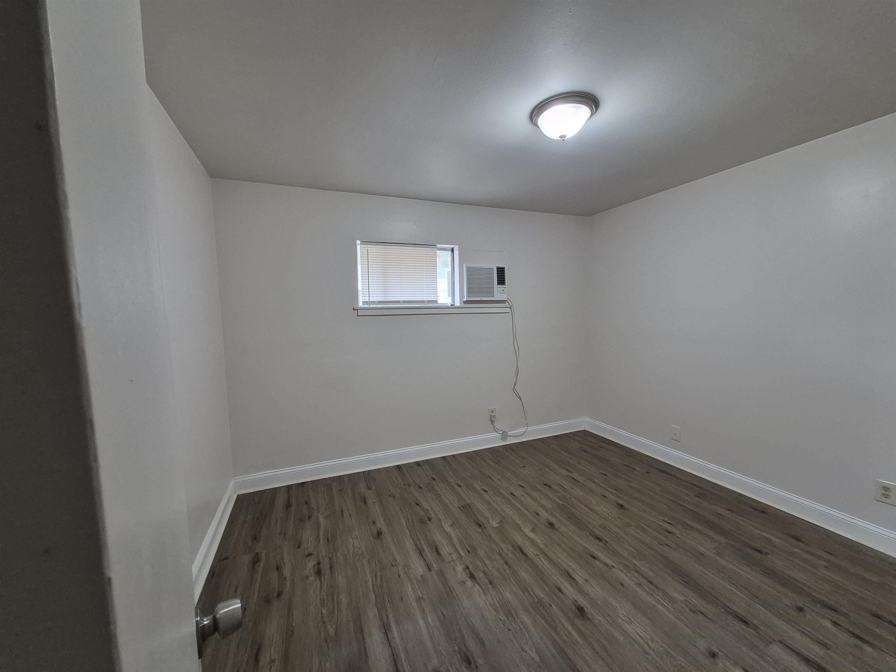3449 Tutwiler Avenue, Unit 3449 Memphis, TN 38122 - Photo 5 of 10 an empty room with wooden floor and windows