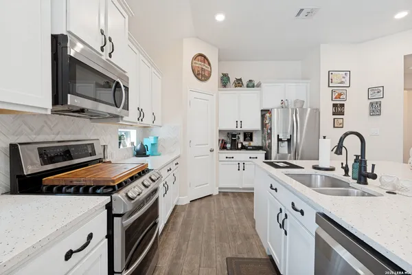 a kitchen with stainless steel appliances granite countertop a sink stove and refrigerator